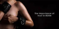 BDSM – Safety, Trust and Pleasure: Close-up of person with handcuffs emphasizing trust.