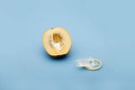 Condom next to a halved melon, showcasing safe sex practices with a light blue background.