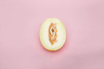 Half melon on pink background symbolizing exploration in "Exploring Sensual Freedom with the Leg Open Restraints Set: A Comprehensive Guide."