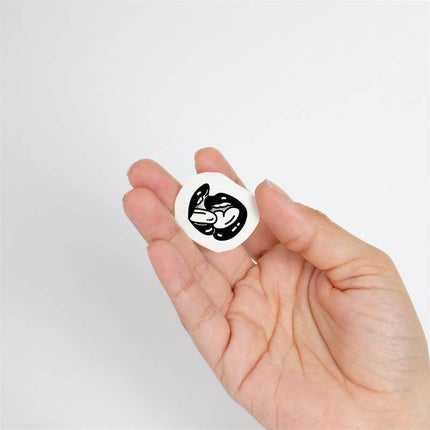 Person holding a black and white tattoo from the 10 temporary tattoos Spicy Collection by Chic Tattoo.