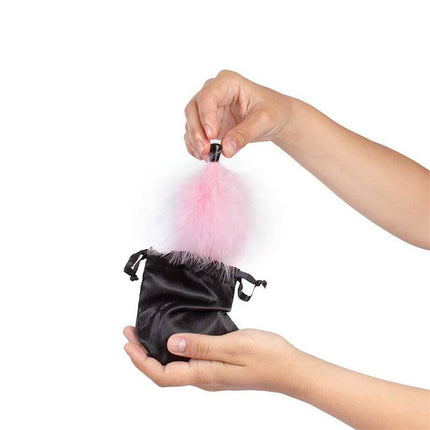 Hands holding pink feather tickler and pouch from 100% Edible Powder Kit and Feather Tickler Sparkling Strawberry set.