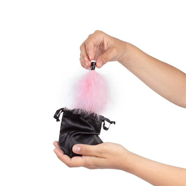 Hands holding pink feather tickler and pouch from 100% Edible Powder Kit and Feather Tickler Sparkling Strawberry set.