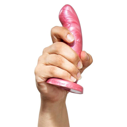 Hand holding Herspot Dildo Golden Rose Size, pink curved toy for G-spot stimulation, designed by Kathy Shubin for luxury intimate experiences