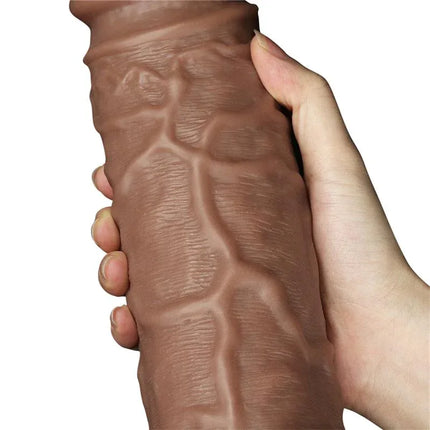 Close-up of the Dildo King 10.5 with Vibration Chubby Brown being held, showcasing realistic texture and size.