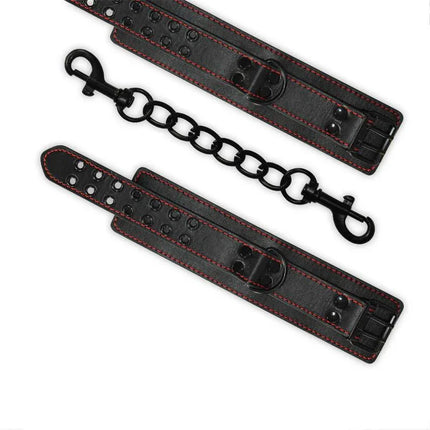 Ankle Cuffs Bondage Black in faux leather with red stitching and chain links for secure and comfortable leg restraint.