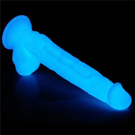 Dildo Lumino Play 10.5 glowing blue in the dark, showcasing its non-toxic glitter and body-safe design.