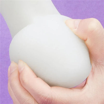 Close-up of Dildo Lumino Play 8.0 being held, showing smooth texture and glow-in-the-dark feature on a purple background.
