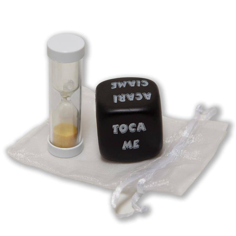 Black six-sided action dice with white text beside a clear hourglass with yellow sand on a white drawstring pouch.