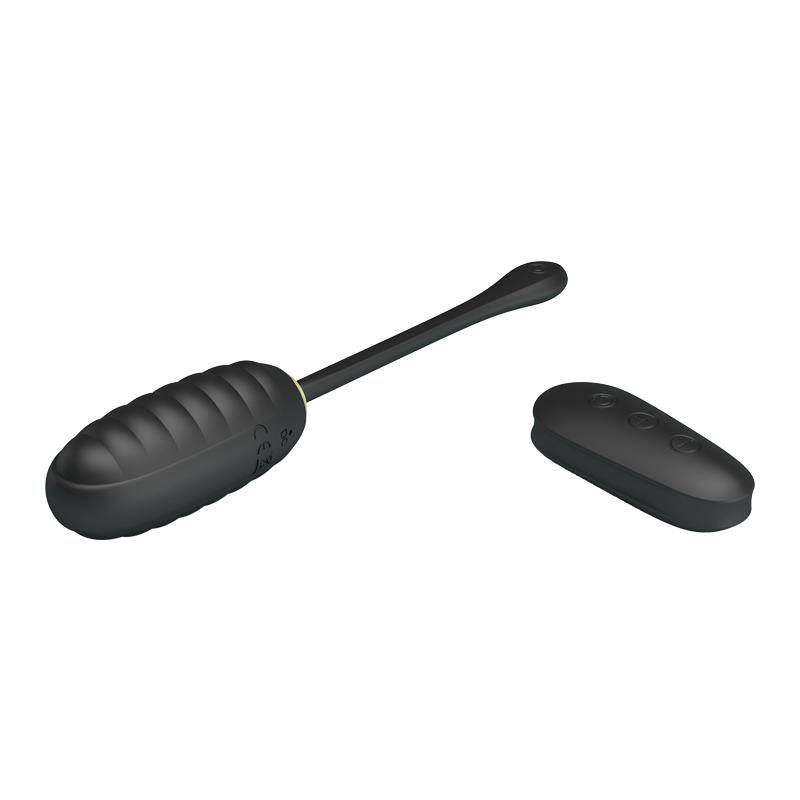 Black silicone kegel ball with ridged texture and flexible retrieval cord next to a slim wireless remote control.