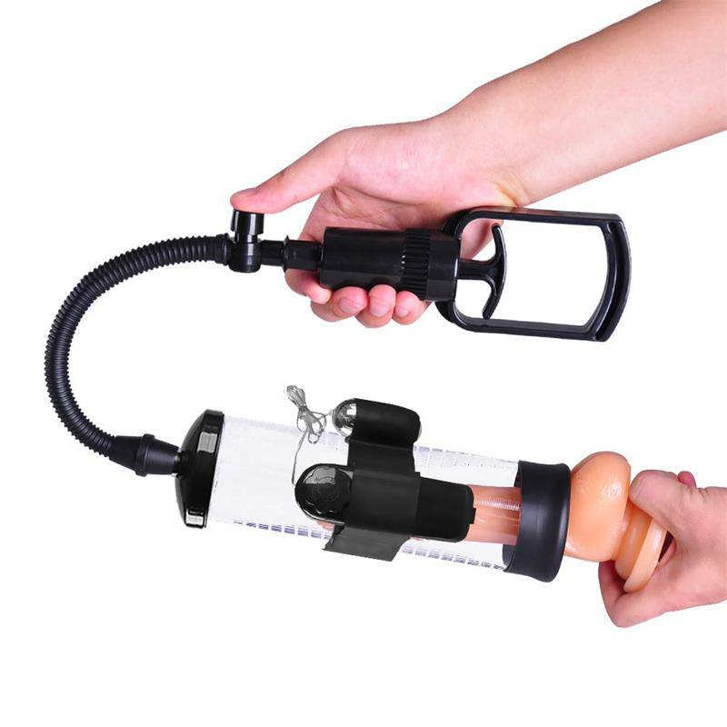 Clear cylinder manual penis pump with black vibration attachment and flexible hose held by hand.