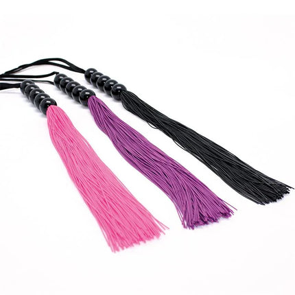 Pink, purple, and black floggers laying side by side.