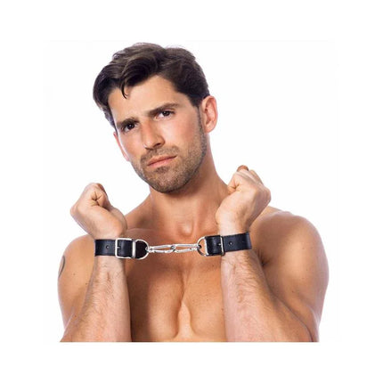 Man wearing black leather Hand and Feet Cuffs 2,5 CM, showing premium BDSM restraint set for adults.
