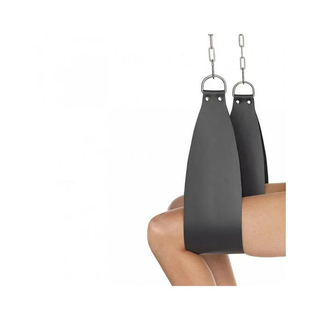 Leg holders, 2 pcs set in black leather with D-shaped rings, displayed in use for adult consensual restraint play.