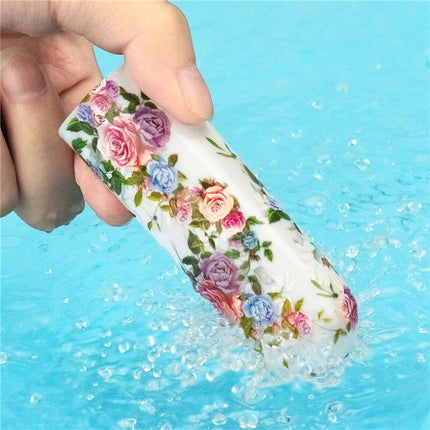 Hand holding waterproof Vibrating Bullet Aphrodite with floral design over water