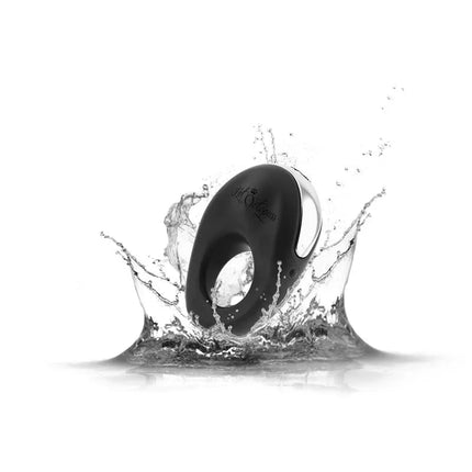 Vibrating Penis Ring Atom Black in splash of water, showcasing waterproof feature and powerful design for enhanced couple's pleasure.