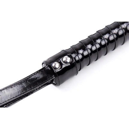 Close-up of the ergonomic handle on the Shinny Handle Flogger 44 cm Black for precise BDSM control.