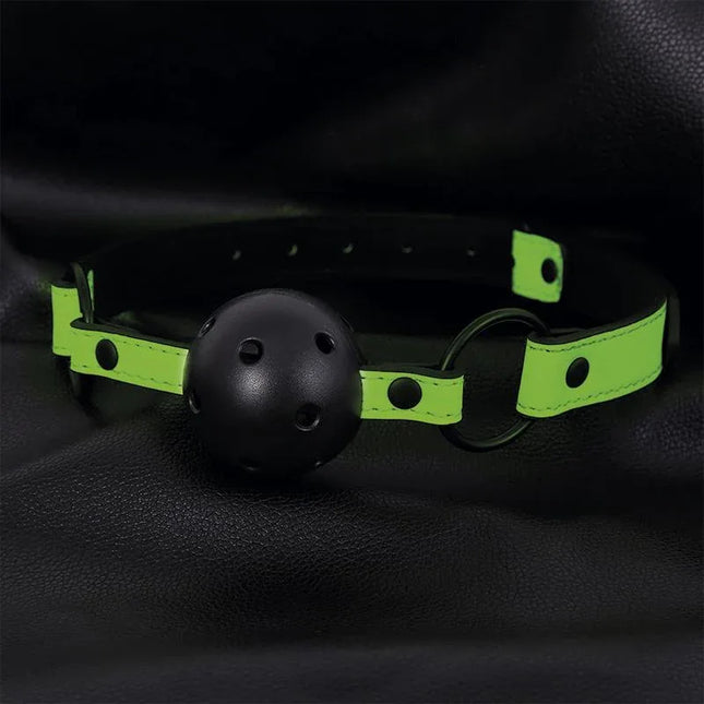 Glow in the Dark Breathable Ball Gag with neon green strap on black leather background.