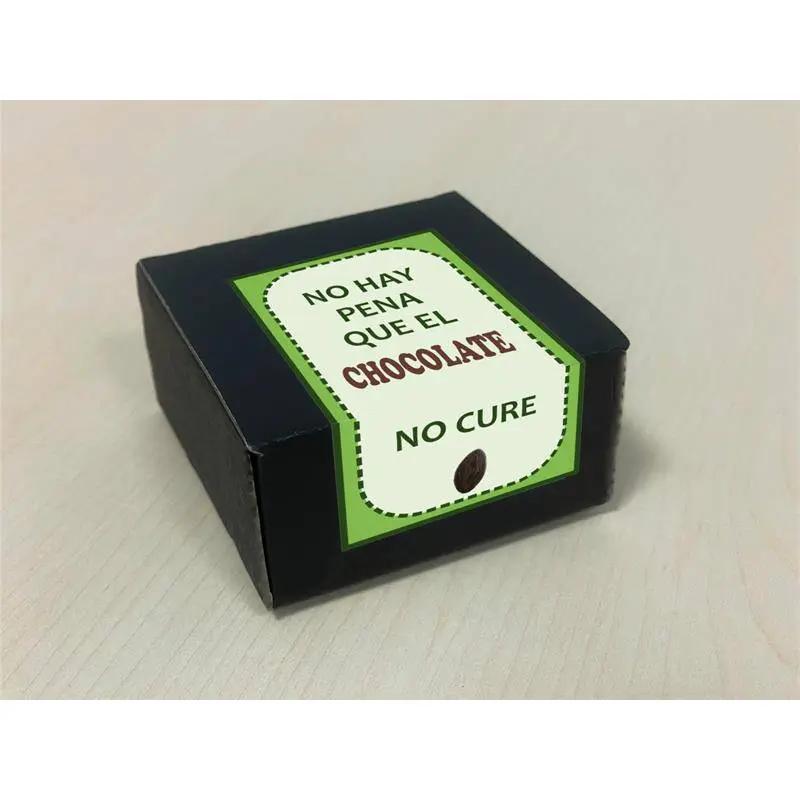 Small black box with white and green label reading "No hay pena que el chocolate no cure".