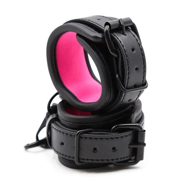Adjustable Neoprene Handcuffs with pink lining, featuring black buckles and straps, designed for comfortable and secure BDSM play.