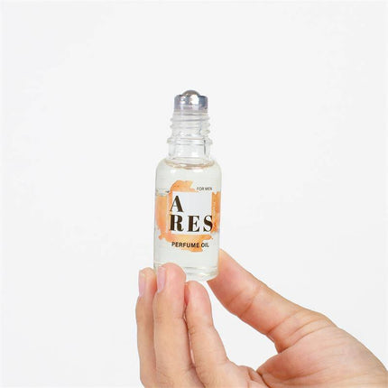 A hand holding Ares Natural Pheromones Perfume Roll-on 20 ml bottle, featuring seductive woody and citrus notes for enhanced allure.