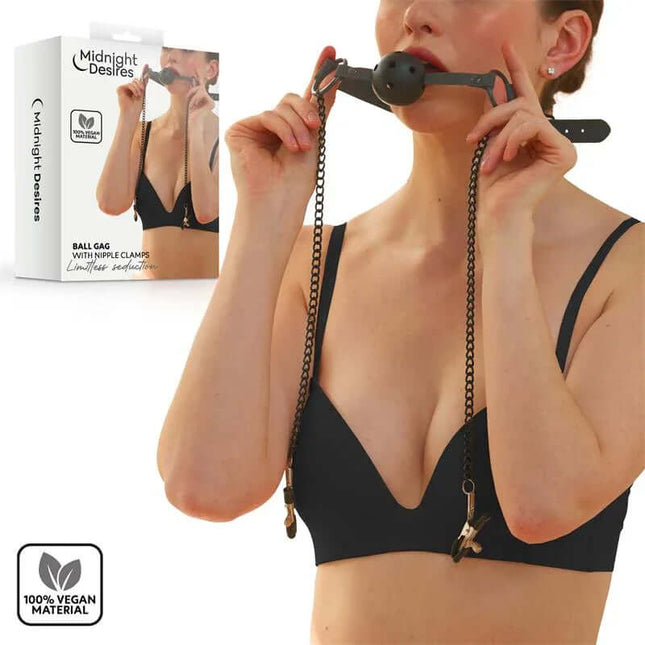 Woman using Ball Gag with Nipple Clamps in black vegan leather set from Midnight Desires packaging.