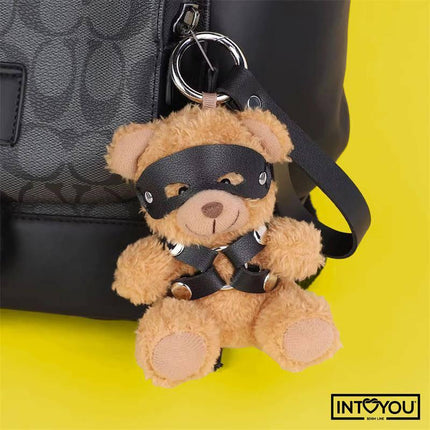 Bearly Keychain BDSM Teddy Bear with Chest Harness hanging on a bag, featuring vegan leather harness and blindfold.