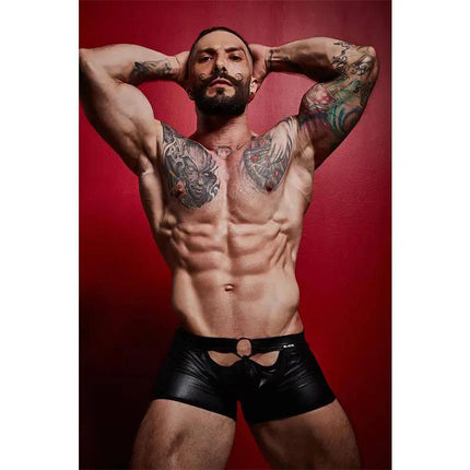 Model wearing BL4CK03 Peekaboo Mini Pants with bold design and leather-inspired look on a red background.