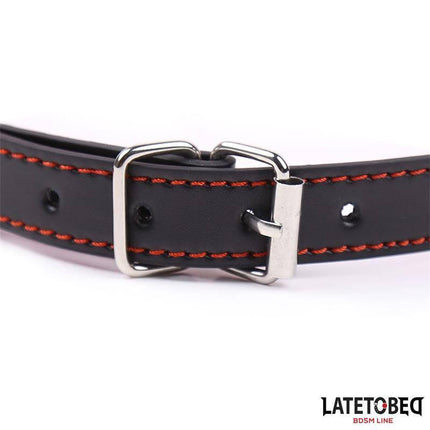 Close-up of black leather buckle with red stitching detail, showcasing the adjustable feature of the Bone Gag Pink Adjustable.