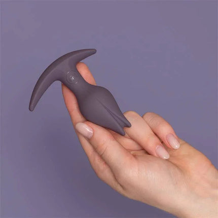 Hand holding Bootie Fem Female anal plug Dark Taupe silicone toy with tulip-inspired shape for vulva owners.