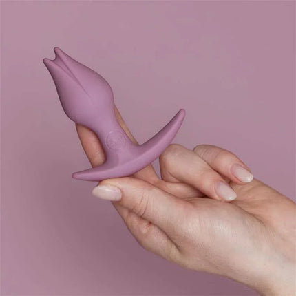 Hand holding Bootie Fem Female anal plug Rose, beginner-friendly silicone plug for vulva owners, tulip-inspired design.