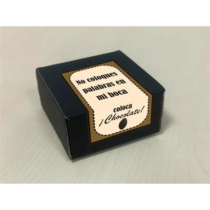Black box with label 'No coloques palabras en mi boca, coloca chocolate', playful gift packaging on a beige surface.