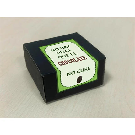 Box with Spanish phrase "No hay pena que el chocolate no cure" on a green and white label, emphasizing chocolate's comforting effects.