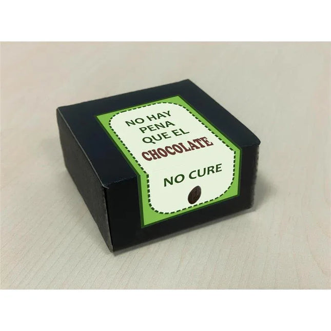 Box with Spanish phrase "No hay pena que el chocolate no cure" on a green and white label, emphasizing chocolate's comforting effects.