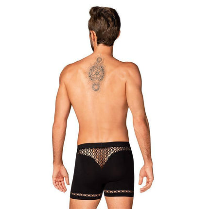 Man wearing black lace boxers, seen from the back. Tattoo on back is visible. Product: Boxers M102 S/M/L in comfortable nylon and elastane.