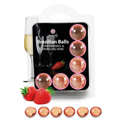 Brazilian Balls Set 6 Strawberries & Sparkling Wine massage oil with packaging, strawberries, and champagne glass.