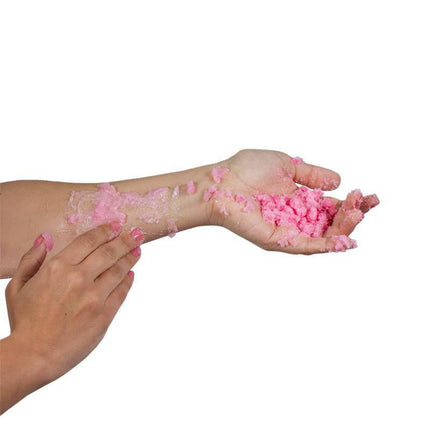 Applying pink Bubbling Bath Salts on arm for exfoliation and relaxation, showcasing skin treatment benefits from Pretty but Wild collection.