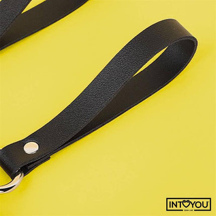 Close-up of Bubu Keychain BDSM Teddy Bear with Chains showing vegan leather strap on a yellow background.