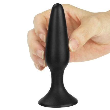 Hand holding Butt Plug Lure Me Size S Black, beginner-friendly silicone anal plug with a smooth, rounded tip for comfortable wear.