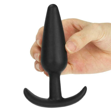 Hand holding Butt Plug Lure Me Size S Black with smooth silicone finish and anchor base for beginners.