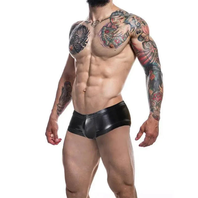C4M Booty Shorts Leatherette Black displayed on a model with tattoos, showcasing a sleek fit and leatherette-inspired finish for bold fashion.