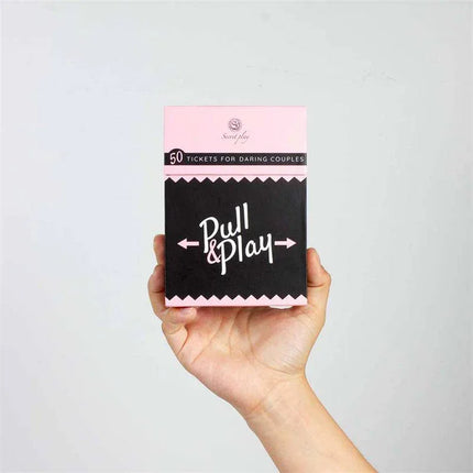 Hand holding a box of Cards Game Pull & Play for couples, designed to enhance intimacy and create new moments of connection.