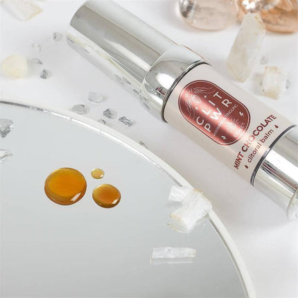 Clit Pwr Mint Chocolate stimulating balm 15 ml for enhanced pleasure and sensitivity displayed on a reflective surface with crystals.
