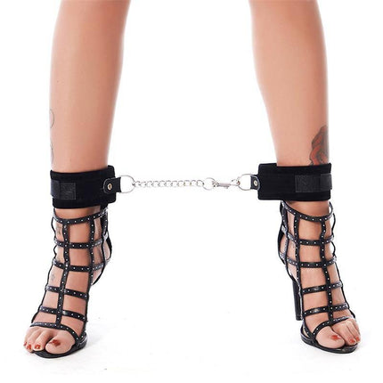 Woman wearing black heels restrained with Complete Restraint Set Black ankle cuffs.