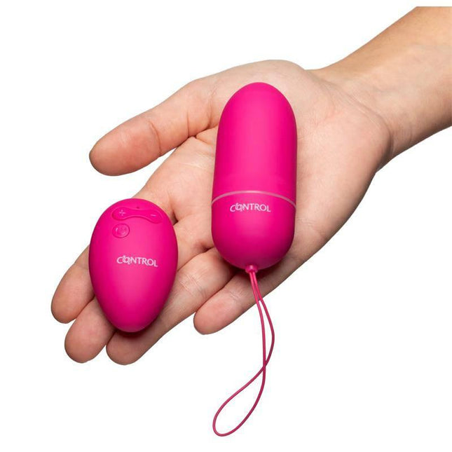 Person holding Control Remote Stimulator with wireless remote in hand.