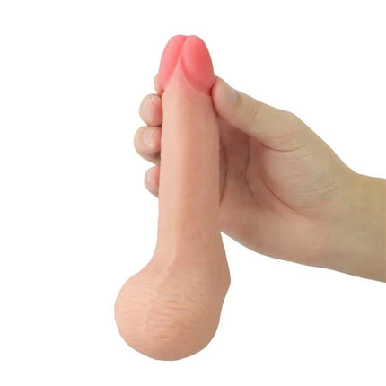 Hand holding Dildo Limpy 100% Flexible 5.5 Flesh with realistic glans tip and testicles, showcasing lifelike flexibility and design.