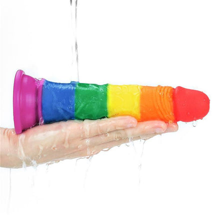 Dildo Prider 7 Liquid Silicone LGBT in vibrant Pride flag colors held under running water for demonstration.
