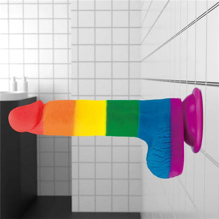 Dildo Prider 7.5 Liquid Silicone LGBT in vibrant pride colors, featuring a suction cup for versatile use in a tiled bathroom setting.