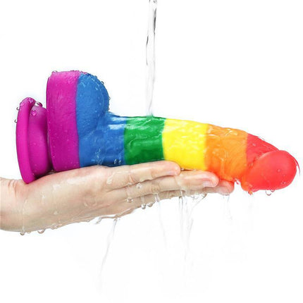 Dildo Prider 8 Liquid Silicone LGBT with Pride flag colors, body-safe and curved design, shown being held under water for easy cleaning.
