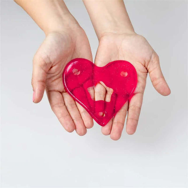 Pair of hands holding a red heart-shaped object for climbing on a white background