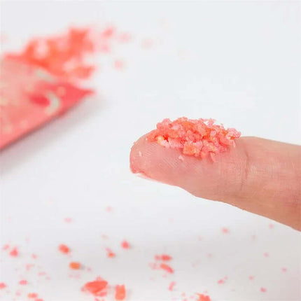 Close-up of Explosive Oral Sex Popping Candies - Single Unit Watermelon Flavor, pink candies on finger, fizzing candy experience.